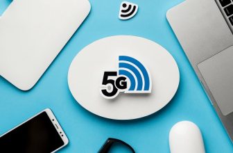 5G-reititin, älypuhelin ja kannettava tietokone työpisteellä