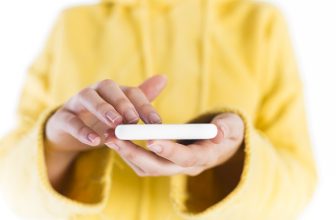 Nainen käyttää älypuhelinta mobiilidatan kulutuksen seuraamiseen