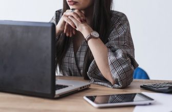 Nainen tutkii puhelinliittymien vaihtoehtoja tietokoneella