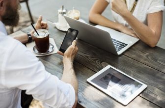 Mies käyttää mobiilitukiasemaa kannettavan tietokoneen yhdistämiseen
