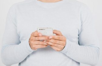 Henkilö pitelee älypuhelinta käsissään
